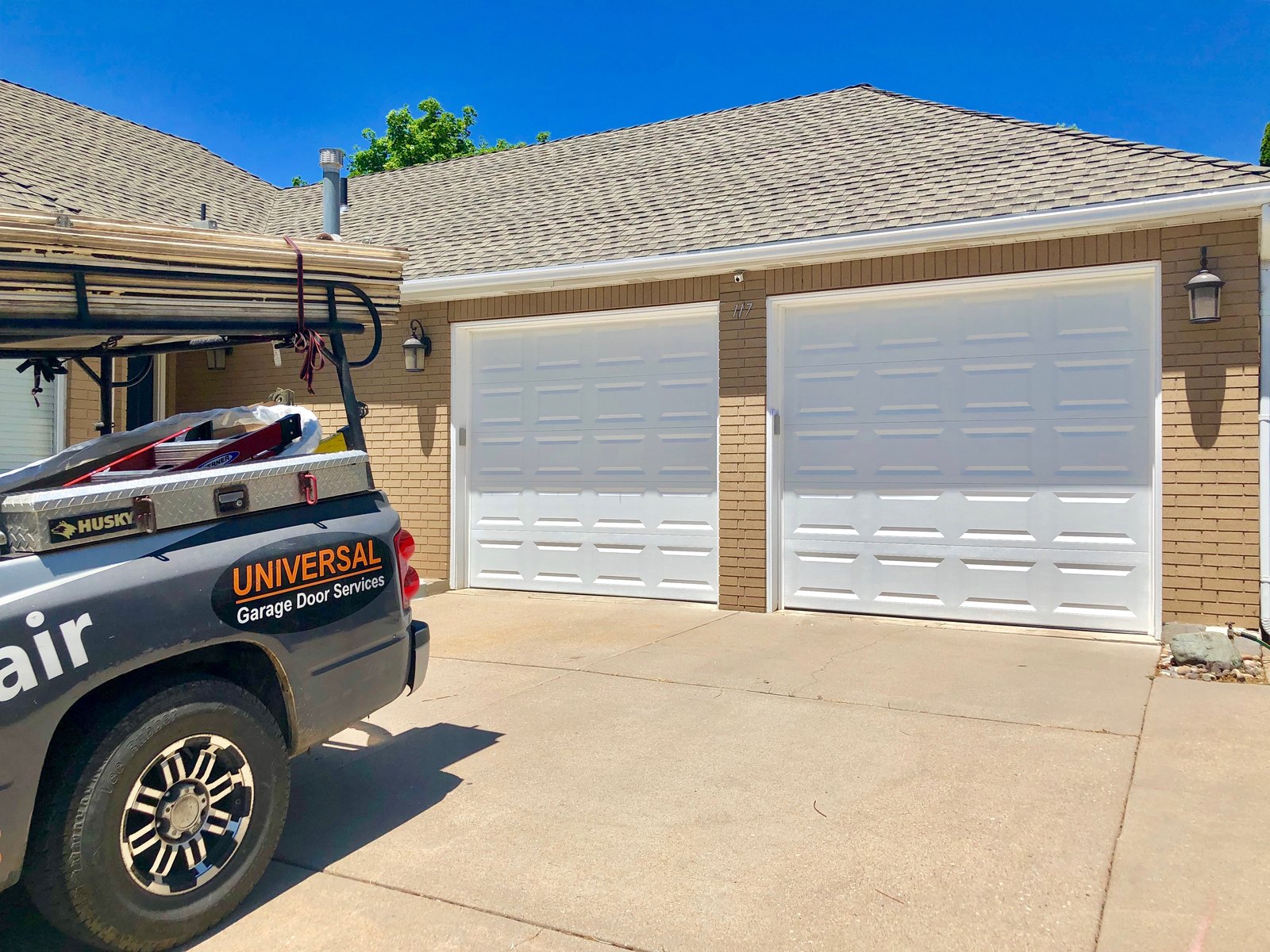 Branded Universal Garage Door Services truck at a residential garage door project